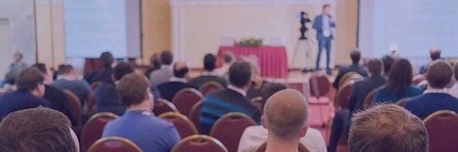 UG Images 318x106-26 man in front of room giving presentation