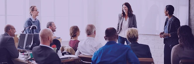 UG Images 318x106-3 smiling female colleague in front of her coworkers