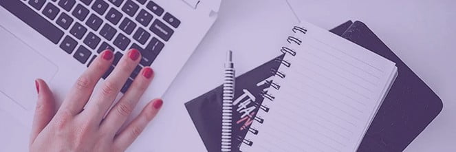 UG Images 318x106-44 womans hand on laptop next to notebook